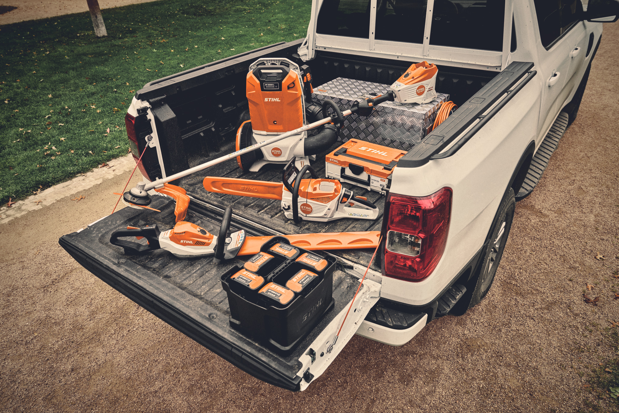 車両の荷台に置かれたSTIHL APシステムの各種バッテリーツールとそれに適したバッテリー