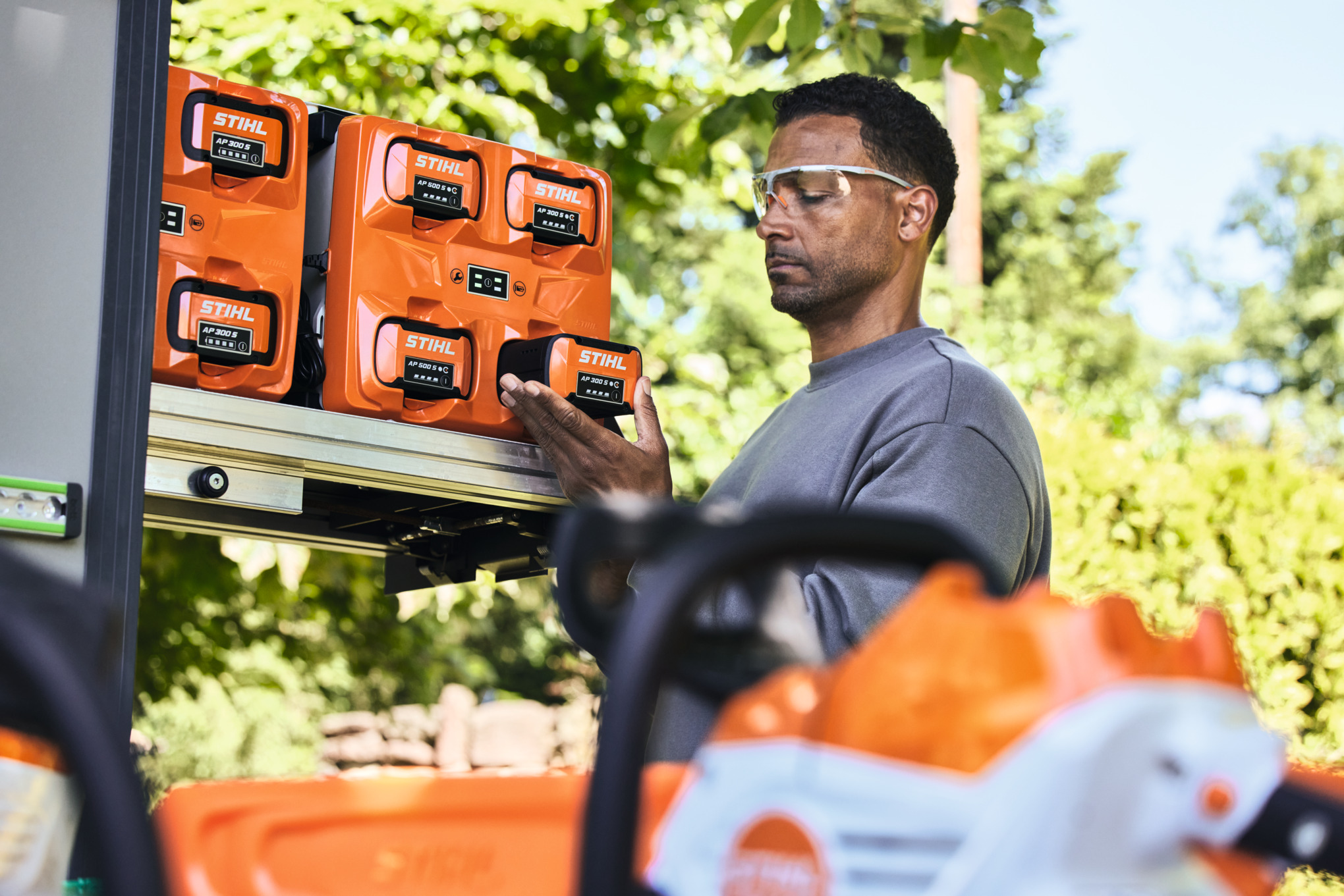 bottTainerからSTIHL AP 300 Sを取り出す保護メガネをかけた男性