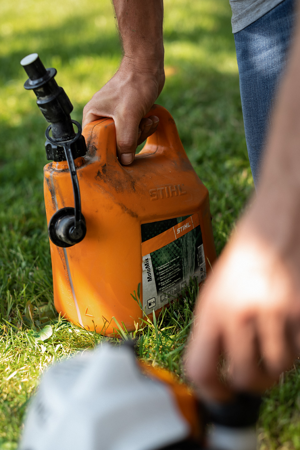 オレンジ色の携行缶に入った刈払機用燃料STIHL MotoMix
