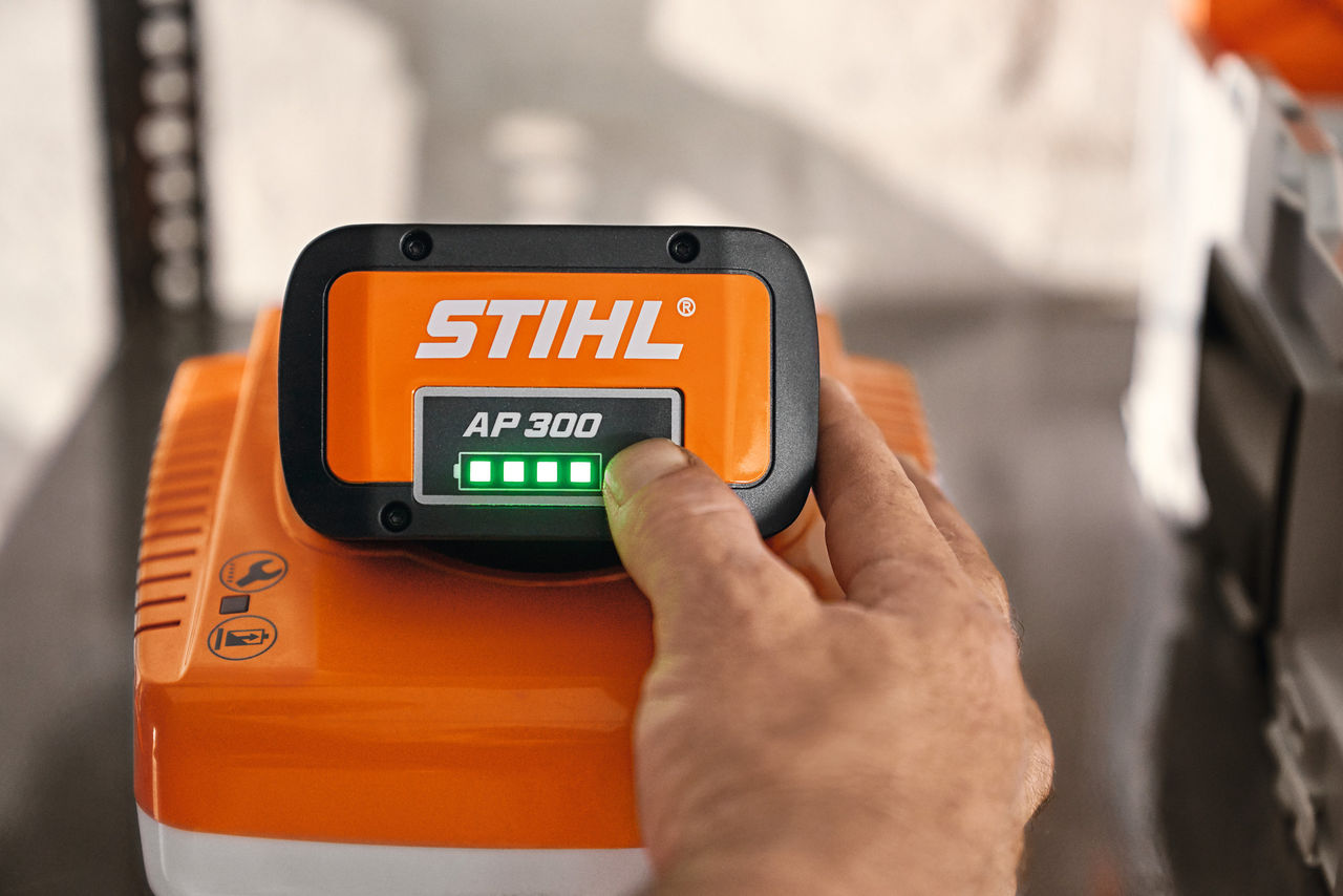 作業員がSTIHLバッテリーボックスのインジケーターライトを指さしているクローズアップ 
